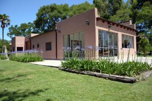 a building with purple flowers in front of it at Yerba buena - Alojamiento rural - Casa principal in Azul