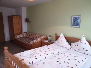 a bedroom with two twin beds and a couch at Gästehaus zum Georgenberg in Goslar +4 photos