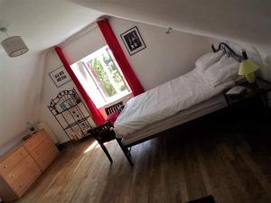 - une chambre avec un lit dans une pièce dotée d'une fenêtre dans l'établissement Ker Jerome - Traditional Stone Breton Cottage near to Dinan, à Trélivan