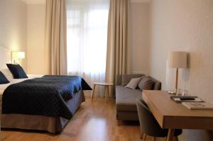 um quarto de hotel com uma cama e um sofá em Mössebergs Kurort em Falköping