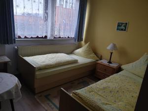a small bedroom with two beds and a window at Gästehaus zum Georgenberg in Goslar