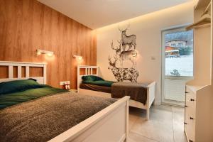 1 dormitorio con cama y cabeza de ciervo en la pared en Sun&Sport Apartament FOREST prywatna sauna w cenie, en Szczyrk