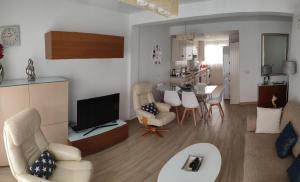 a living room with a television and a dining room at Apartamento Cervantes in Fuengirola
