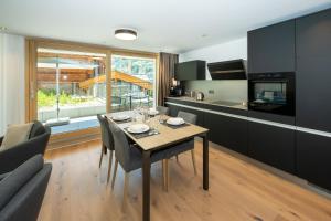 a kitchen and dining room with a table and chairs at Luxury Residence Colosseo Zermatt in Zermatt