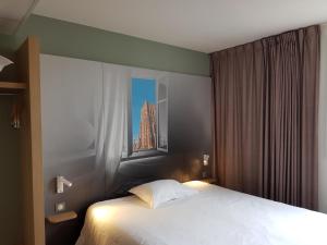 une chambre d'hôtel avec un lit et une fenêtre dans l'établissement B&B HOTEL Béthune Bruay-la-Buissière, à Bruay-la-Buissière