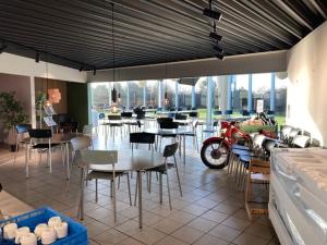 a restaurant with tables and chairs and a motorcycle parked in a room at Motel Trafikcenter Sæby in Sæby