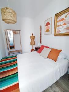 um quarto com uma cama branca e um espelho em MAJU Concept House - Beja Centro Histórico em Beja