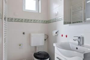 a white bathroom with a sink and a toilet at Villa Olivia in Veprinac +9 photos