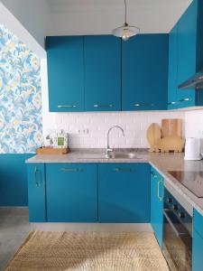 a kitchen with blue cabinets and a sink at MAJU Concept House - Beja Centro Histórico in Beja