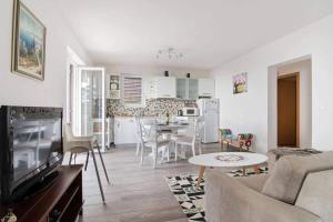 a living room with a couch and a table and a kitchen at Villa Olivia in Veprinac
