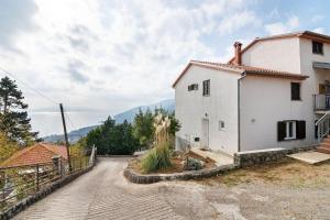 a small white house with a hill in the background at Villa Olivia in Veprinac
