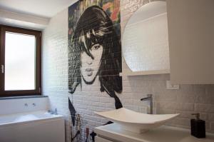 a bathroom with a mural of a woman on the wall at Il nido di Marty in Issogne