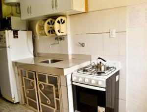 a kitchen with a stove and a sink and a refrigerator at Casitas de Norma in Embalse