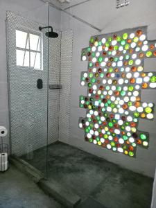 a bathroom with a shower with a wall of spheres at Acacia Cottage in Maun