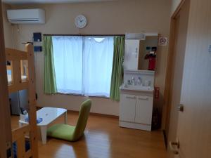 um pequeno quarto com uma mesa e uma janela com um lavatório em 冨の露～とみのつゆ～ em Setouchi