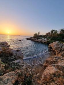 un tramonto su una spiaggia con rocce e l'oceano di Yiota's Cute Studio a Paphos