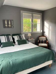 a bedroom with a large bed and two windows at Les Glycines in Croix