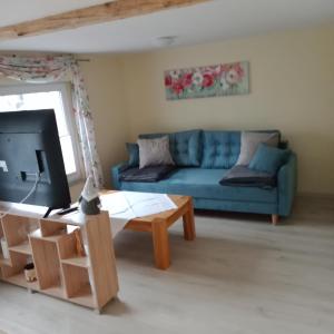 a living room with a blue couch and a coffee table at Drahtesel Oase in Pömmelte
