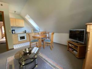 una cucina e una sala da pranzo con un tavolo e una televisione di App 3 a List 1 altra foto