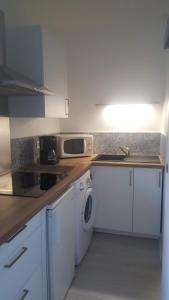 a kitchen with a sink and a washing machine at Agréable studio bord de mer in Saint-Cyprien