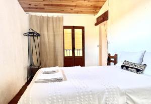 a white bed in a room with a window at Casa Yolanda in Bojar