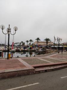 a marina with boats in the water and street lights at Agréable studio bord de mer in Saint-Cyprien