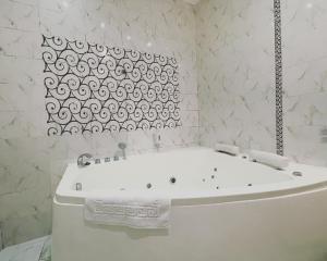 a white bath tub in a bathroom with a window at Двокімнатні апартаменти на Лукіяновича, 3 in Lviv +4 photos