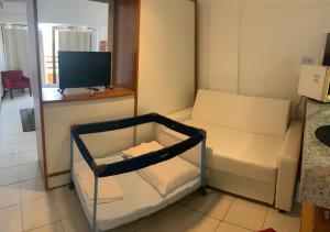 Habitación pequeña con sofá y TV. en Casa na Beira da Praia da Pipa Beach House Luxury en Pipa