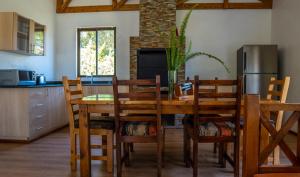 a kitchen with a table and chairs and a refrigerator at Black Wattle House in Nakuru