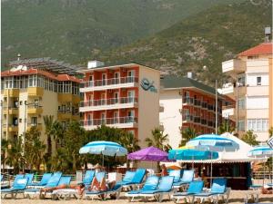 eine Gruppe von Stühlen und Sonnenschirmen am Strand in der Unterkunft Kleopatra Balik Hotel in Alanya