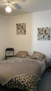 1 cama en una habitación con 2 pinturas en la pared en APPARTEMENT T2 GRUISSAN PLAGE DANS RÉSIDENCE CALME, en Gruissan