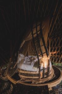 a bed in a room with a net at Veluvana Bali in Sidemen