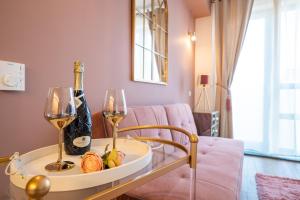 a living room with a glass table with two wine glasses at Signature Aparthotel - Boutique in Galaţi