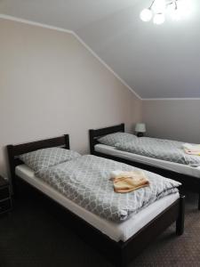 two twin beds in a room with at Villa Dobry Adres in Dziemiany