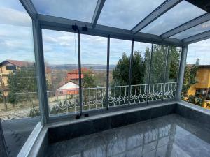 a room with a view of a balcony with windows at Butik Hotel Maşukiye in Masukiye