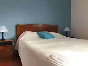 a bed with a blue pillow on top of it at Camping Villa Park Zambujeira do Mar in Zambujeira do Mar