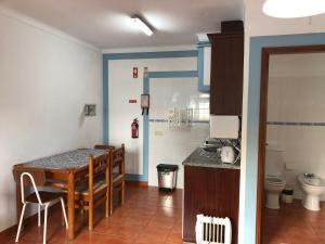 a kitchen with a table and chairs in a room at Camping Villa Park Zambujeira do Mar in Zambujeira do Mar