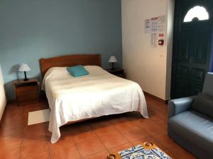 a bedroom with a bed with a blue pillow on it at Camping Villa Park Zambujeira do Mar in Zambujeira do Mar