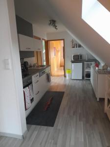 a kitchen with white cabinets and a staircase in a room at FeWo Karola in Ellenz-Poltersdorf