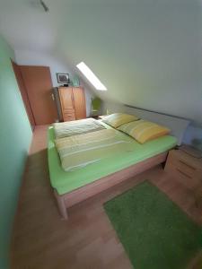 a bedroom with a green bed with a green rug at FeWo Karola in Ellenz-Poltersdorf