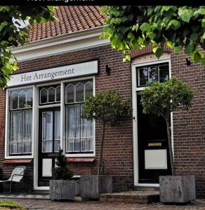 a red brick building with a her amendment sign on it at Het arrangement in Wemeldinge