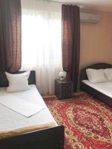 エイスクにあるGuest house on Shmidta-комнаты для летнего отдыхаのベッド2台と窓が備わるホテルルームです。