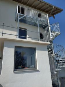 a white house with a staircase and a balcony at wolke31 in Grassau