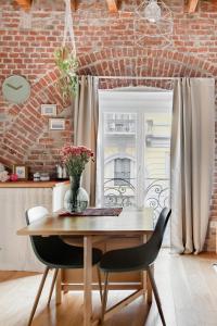 een eetkamer met een tafel en stoelen en een bakstenen muur bij Ripa Apartments Milano - Ripa 57 in Milaan