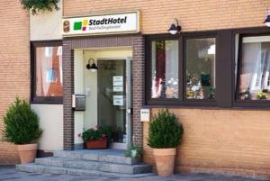 a store with potted plants in front of a building at StadtHotel Bad Fallingbostel in Bad Fallingbostel