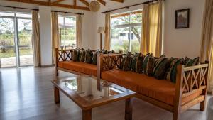 un soggiorno con divani e tavolo in vetro di Yellowwood House a Nakuru
