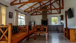 uma sala de estar com mobiliário em madeira e uma televisão em Yellowwood House em Nakuru