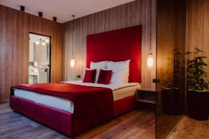 a bedroom with a large bed with a red headboard at Boutique Hotel Cattaleya in Bacău