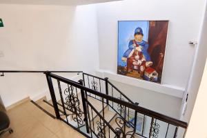 a staircase with a painting of a man with a dog at Hotel Colonial Internacional in Bogotá