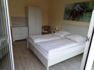 a bedroom with a bed, desk and a painting on the wall at Airport Park Hotel MUC in Hallbergmoos